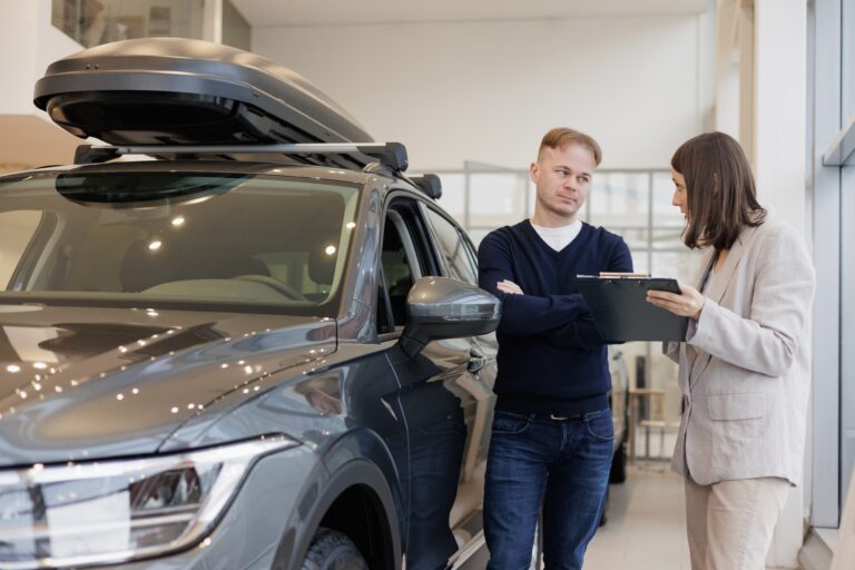 female salesperson and car rental helps with the purchase. signing a trade-in contract and handing