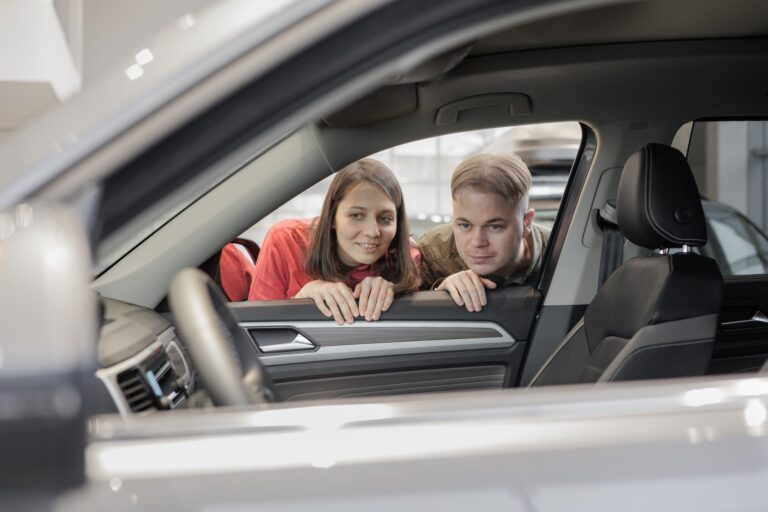 man and a woman couple in a car dealership buy or trade in. car rental or repair service. happy and
